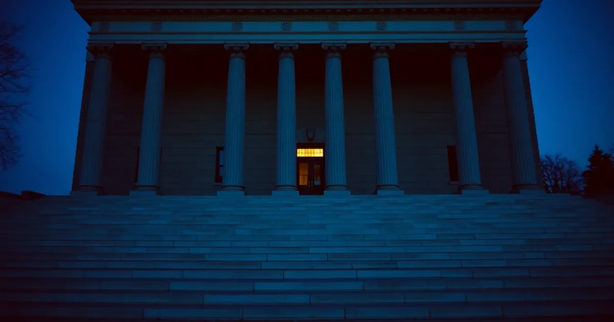 The colonnade of a neoclassical federal building at dusk, illustrating Treaty-based return position and 8833