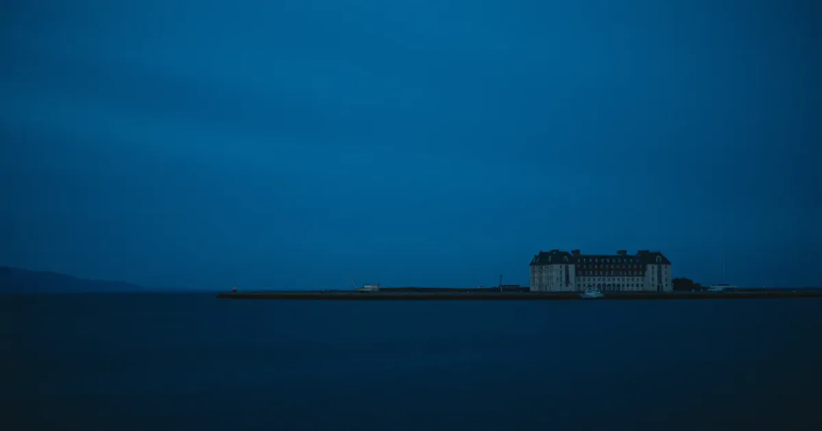 Two coastlines facing each other across a narrow strait, illustrating private medical insurance and US tax