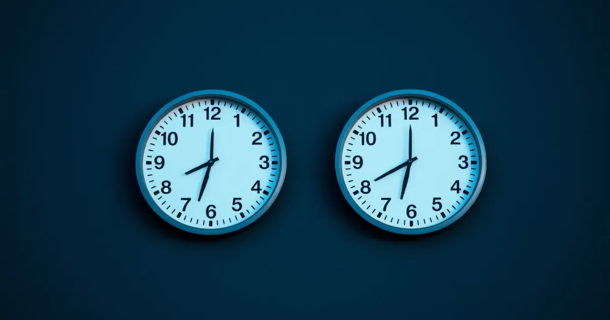 Two clocks on a dark wall showing different hours, illustrating UK bank account for a US citizen